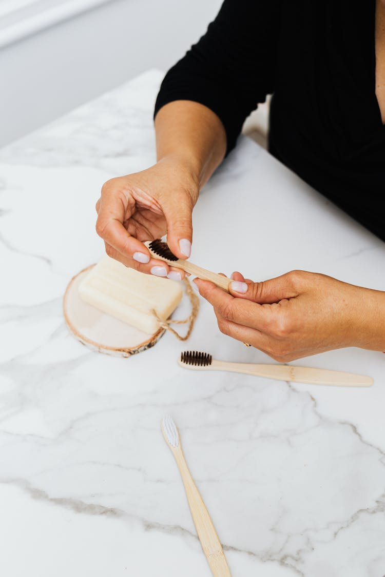 Person Holding A Wooden Toothbrush