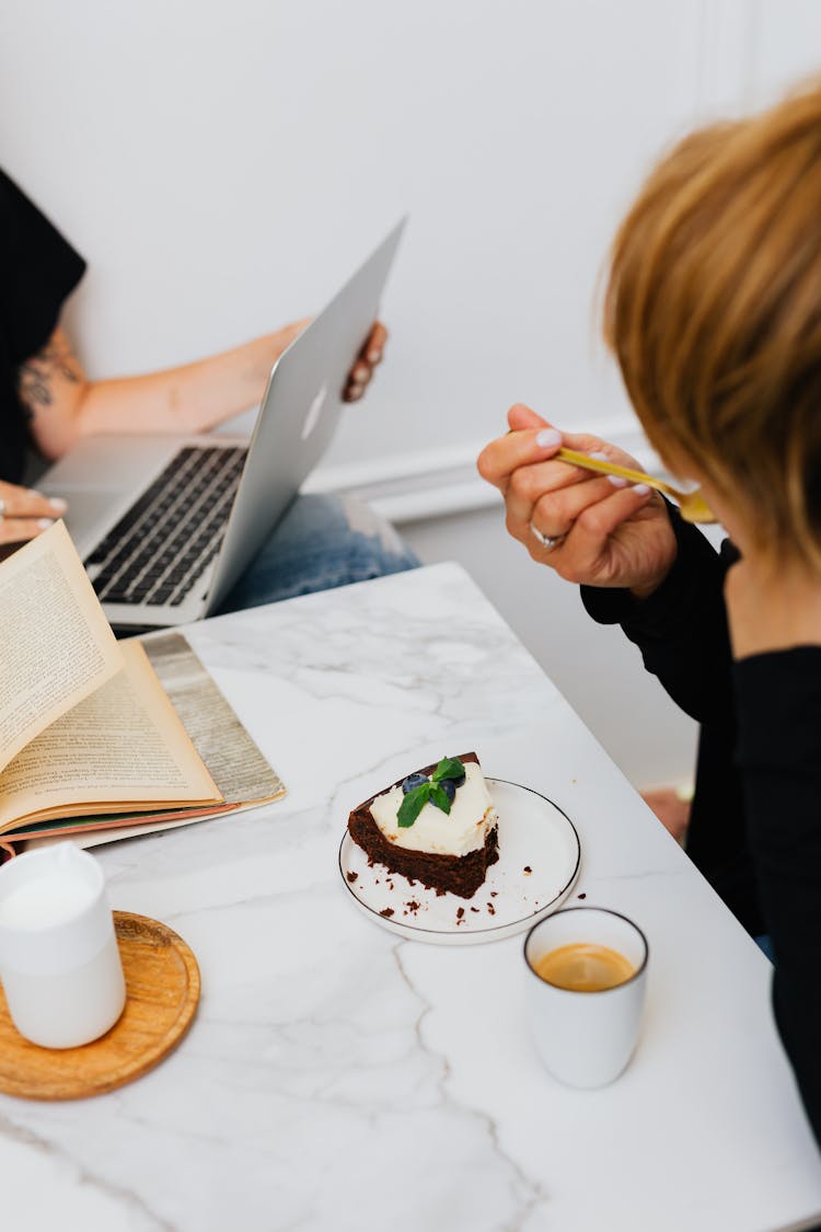 Woman In Black Long Sleeves Eating A Chocolate Cake