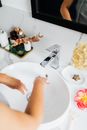 Person Washing Hands on a Ceramic Wash Basin