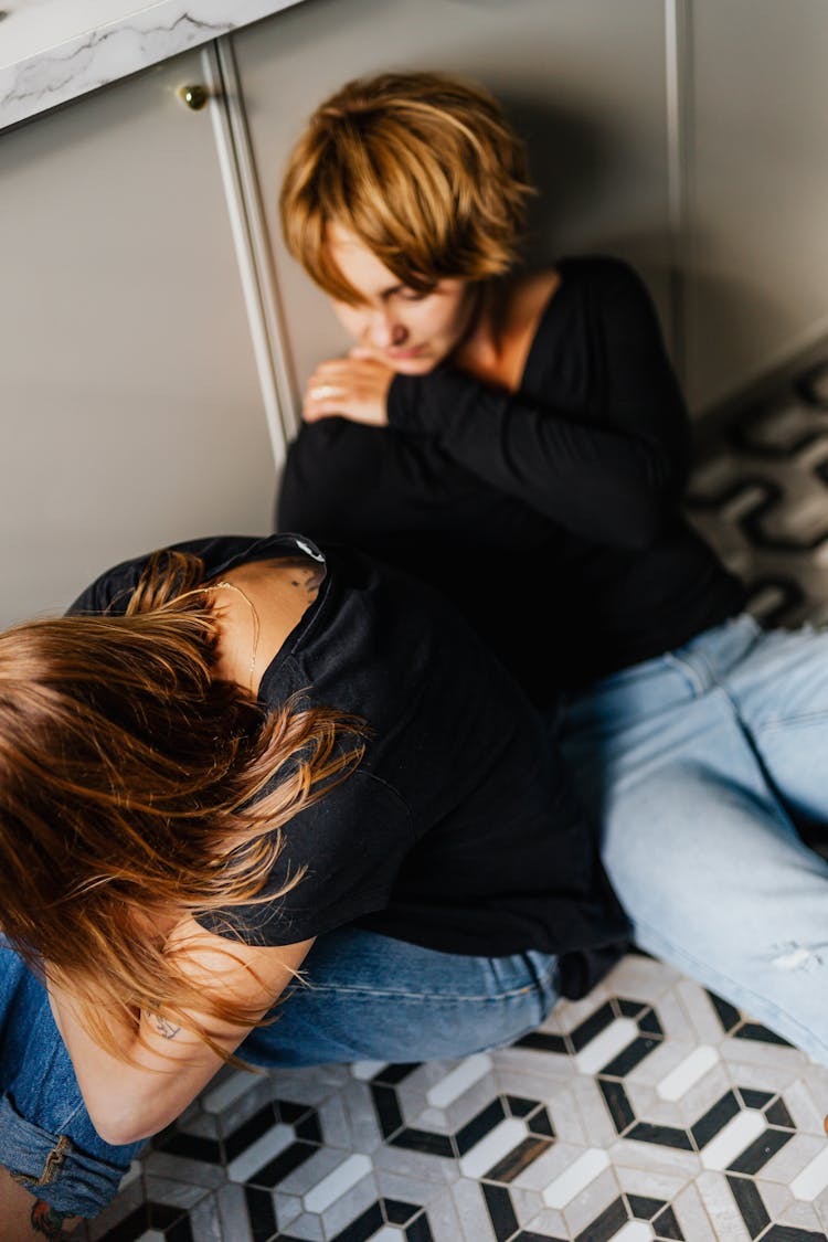 A Couple In Black Top And Denim Jeans Consoling Each Other