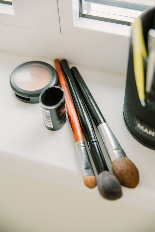 Makeup brushes with powder on windowsill