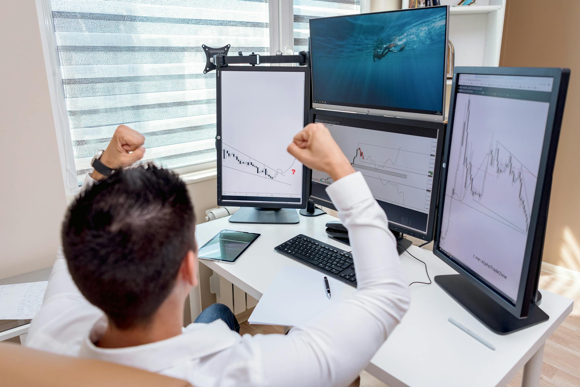 Man in White Long Sleeve Shirt Clenching Fists on Work Table