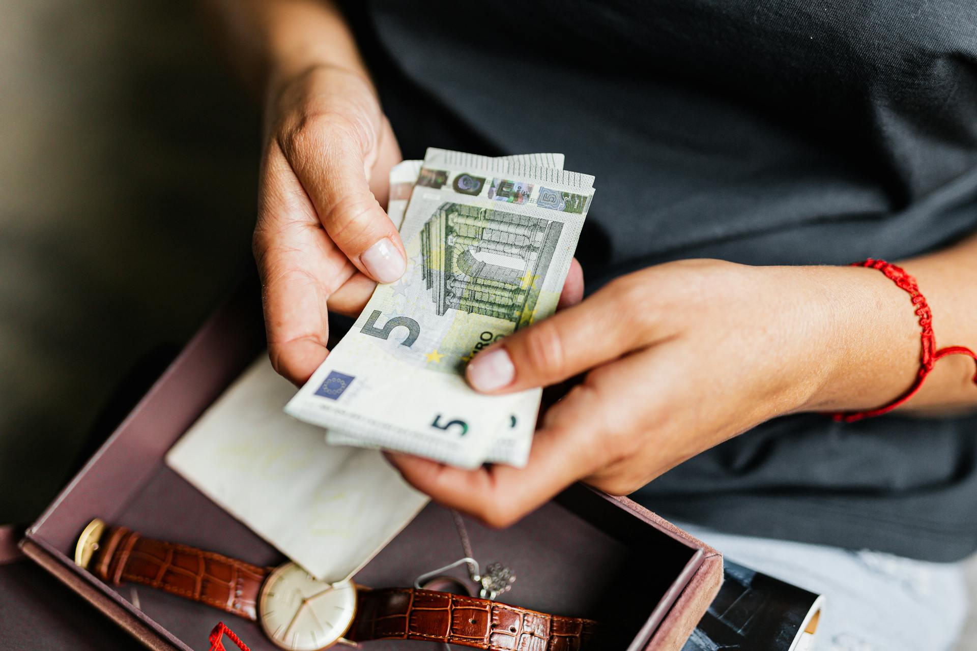 Hands of a Person Holding Cash Bills