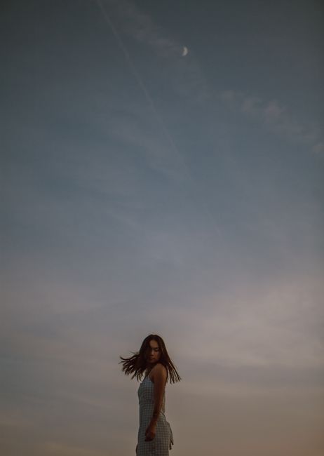 Side view of peaceful female whipping hair while enjoying freedom at sunset in nature