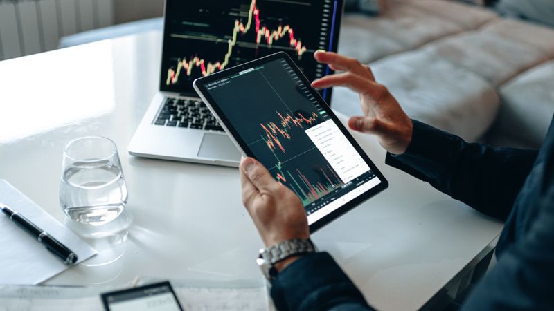 Comparing financial data on a tablet and a laptop