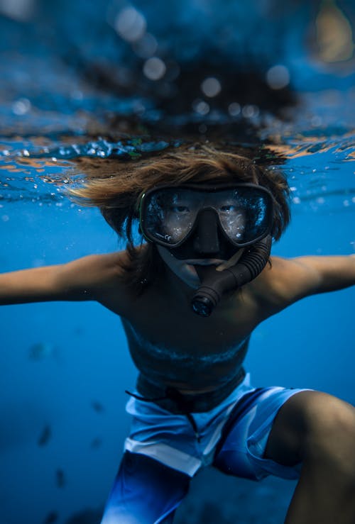 Boy snorkeling in mask underwater