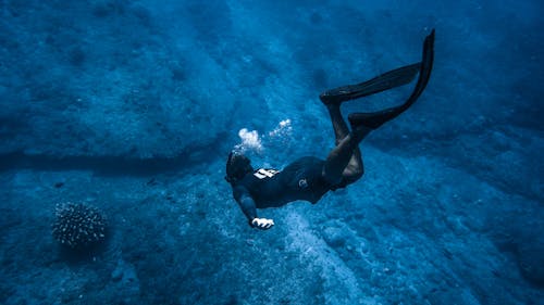 Unrecognizable person diving above rocks