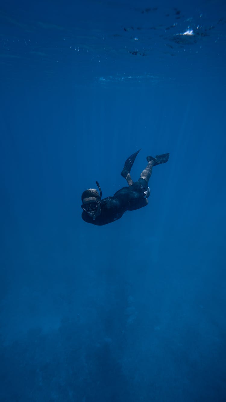 Anonymous Person Diving Underwater In Sea