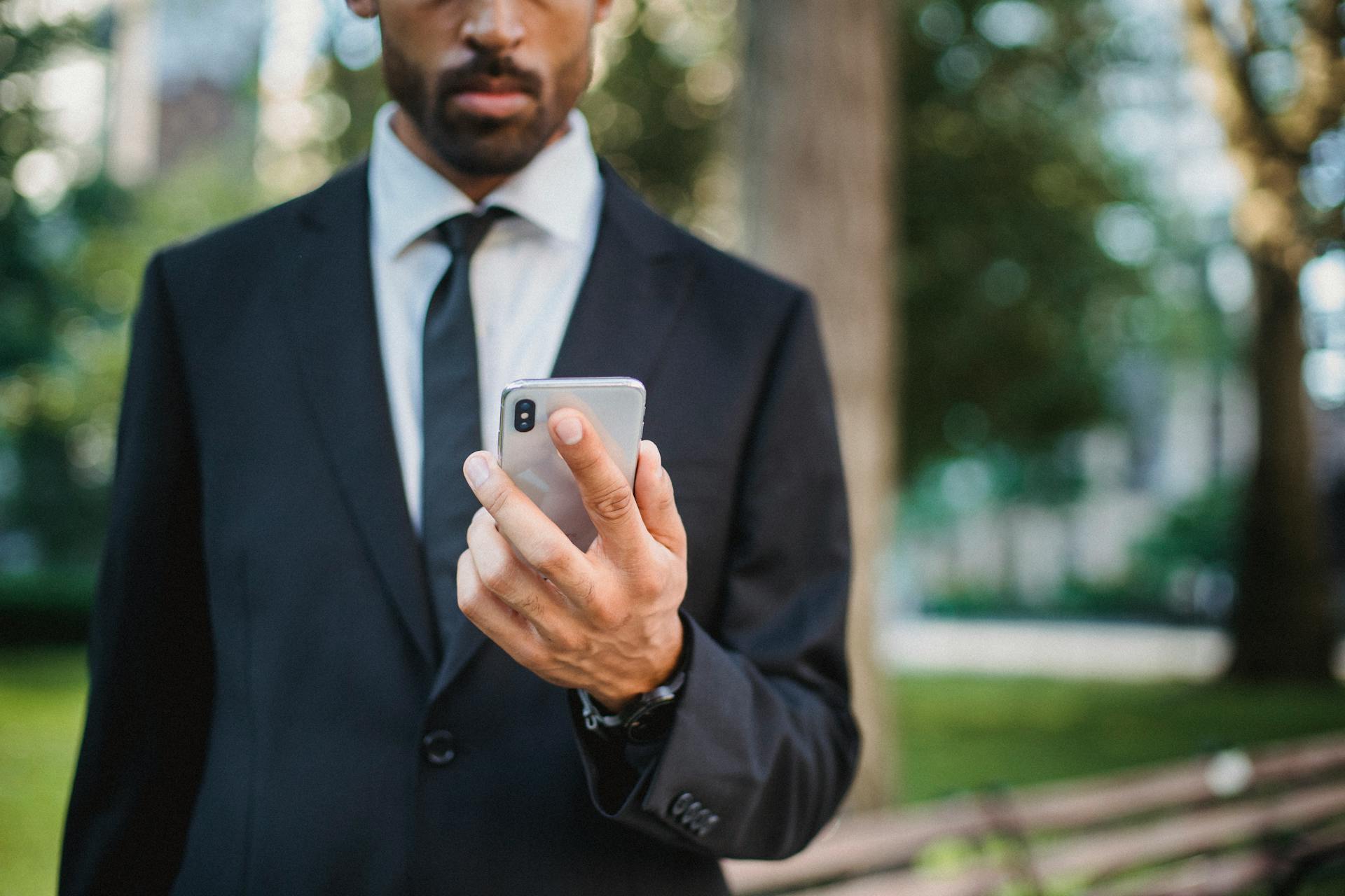 A Man in a Black Suit Holding a Mobile Phone