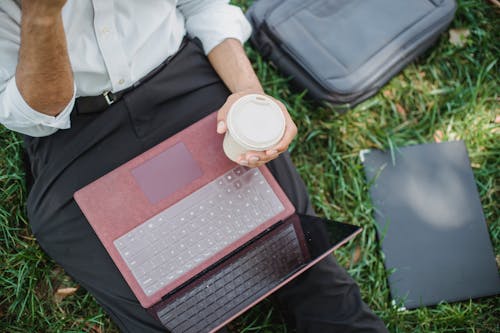 Close-Up Photo of a Person Holding a Disposable Cup