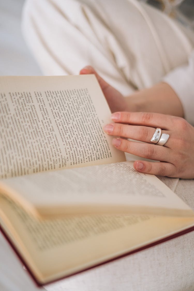 Person Wearing Silver Ring Holding A Book