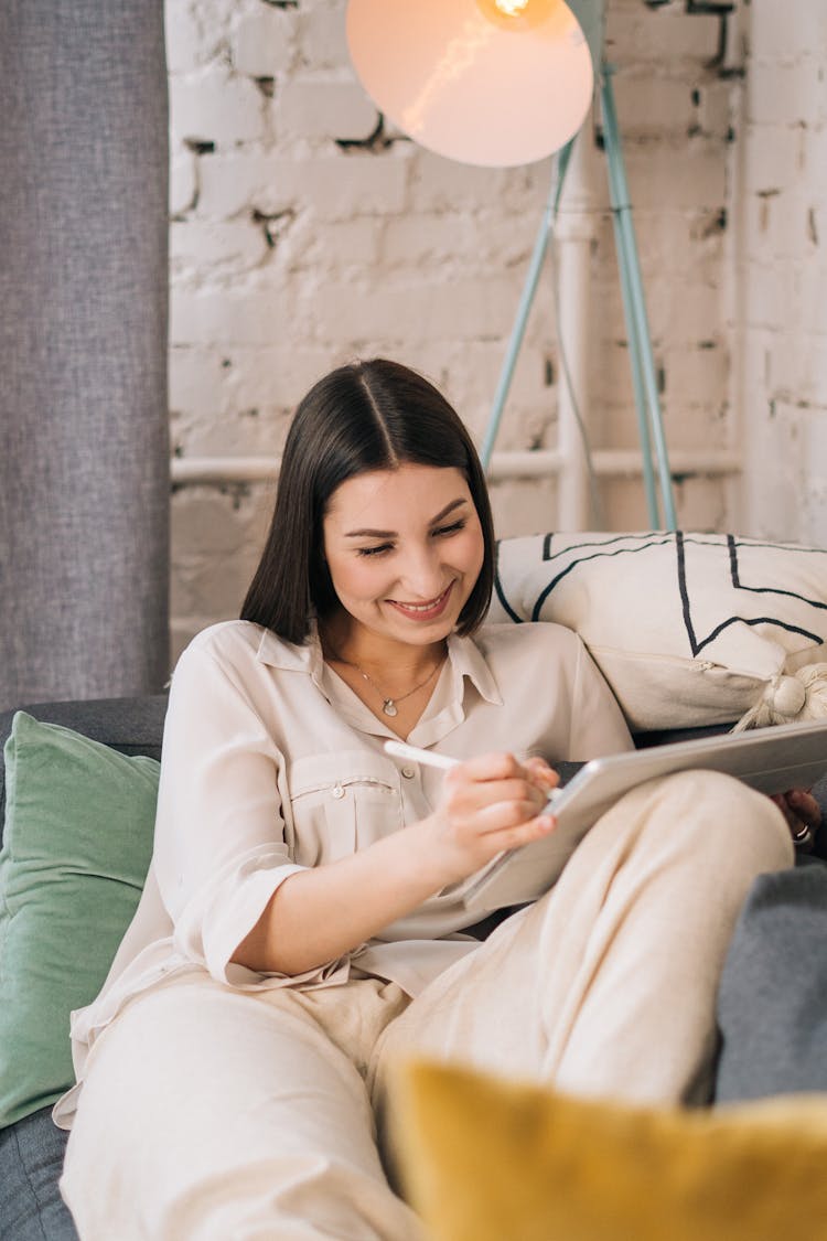 Woman With Tablet Sitting On Sofa