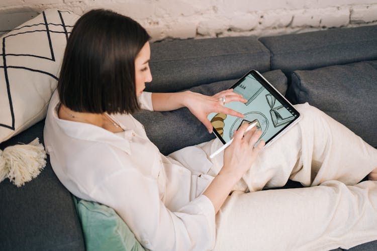 Woman In White Long Sleeve Shirt Using A Tablet Computer