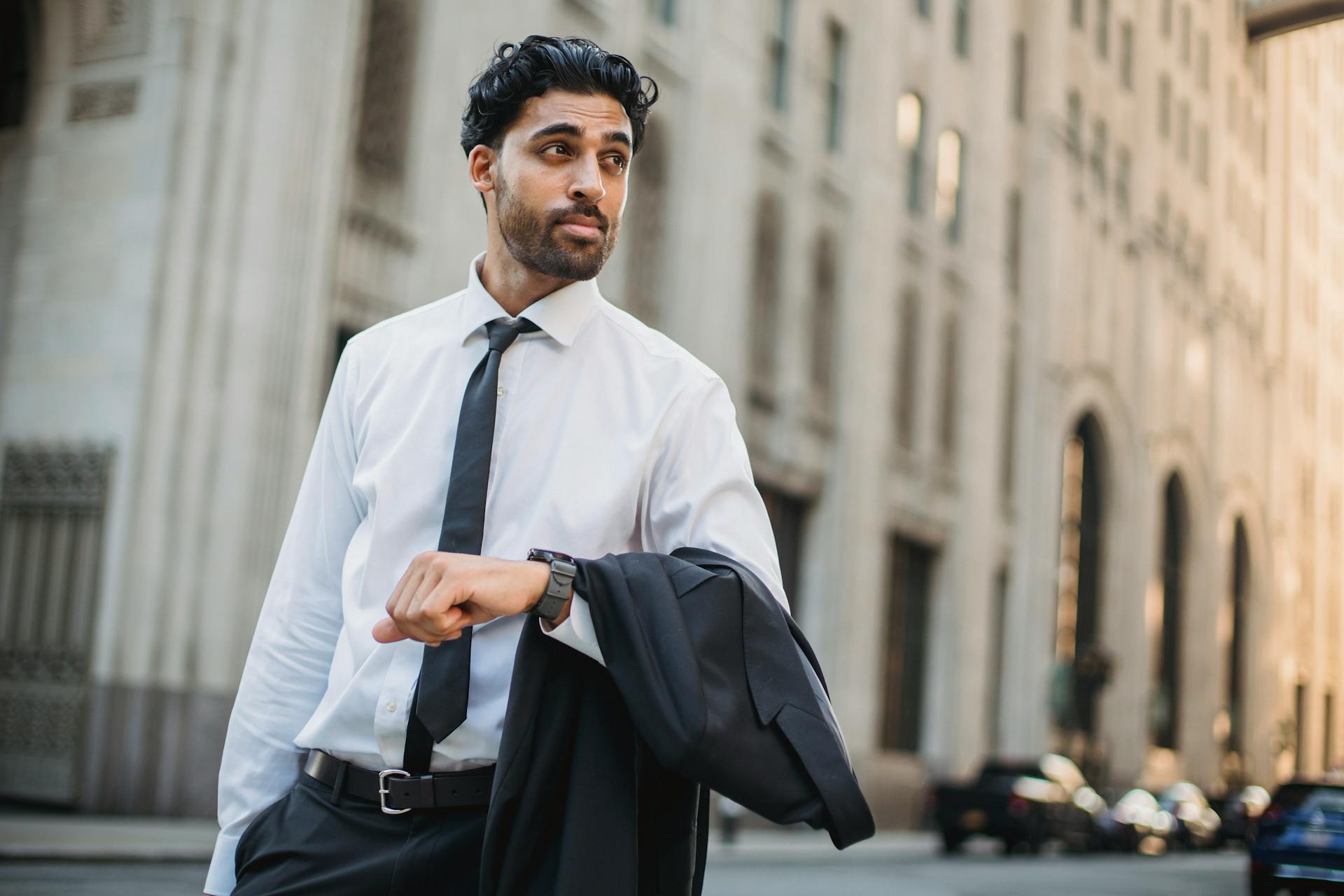 Confident businessman in a suit walking through an urban setting, exuding professionalism.