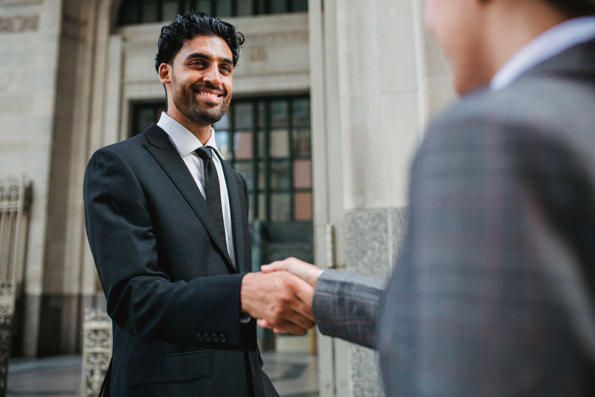 Two professionals shaking hands on a partnership.