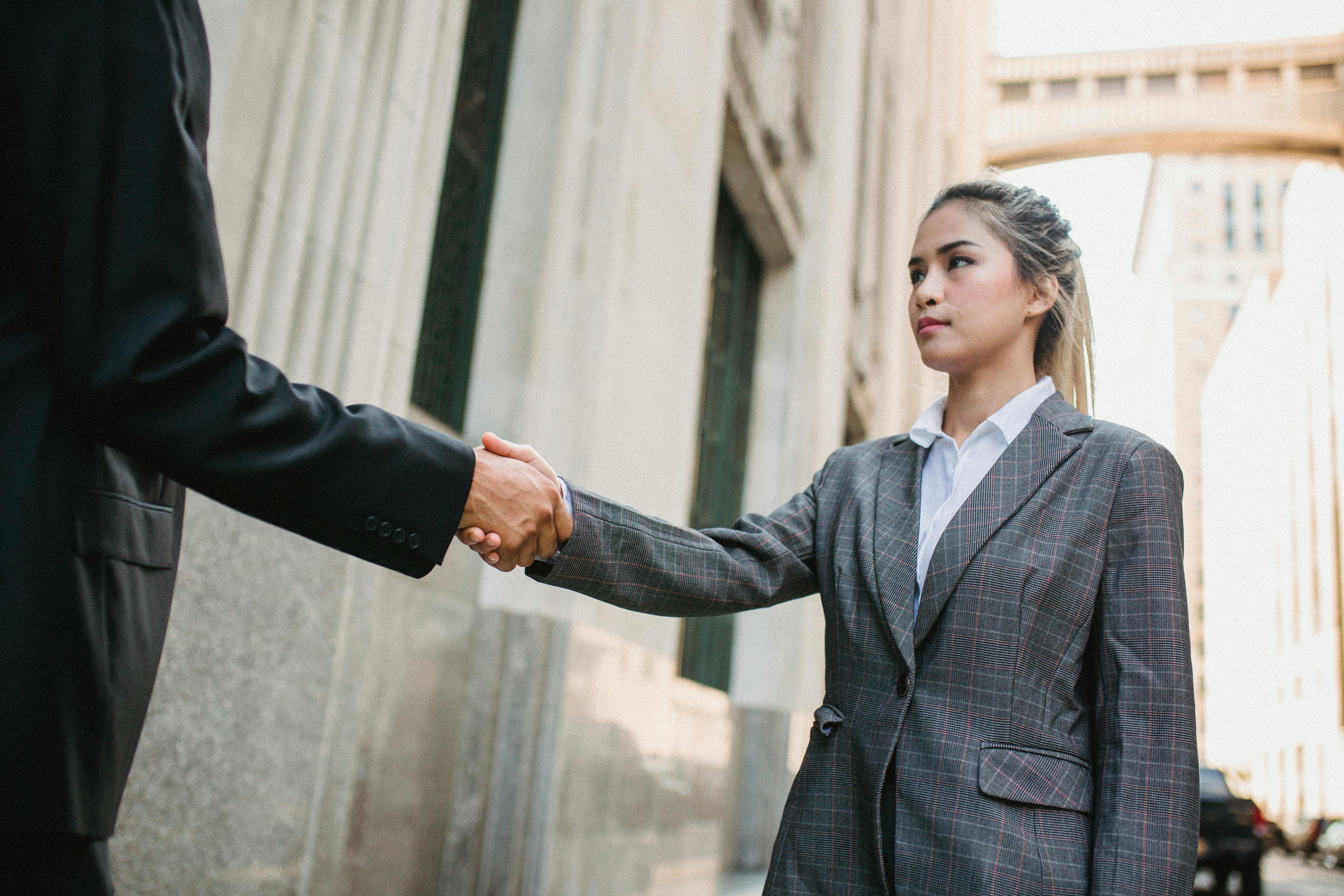 young business woman shake hands with unrecognizable man