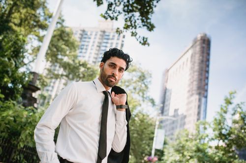 Free Elegant businessman holding jacket in a cityscape, exuding confidence and style. Stock Photo