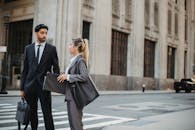 两位商务人士在城市街道上讨论，展现了正式着装与城市环境的融合