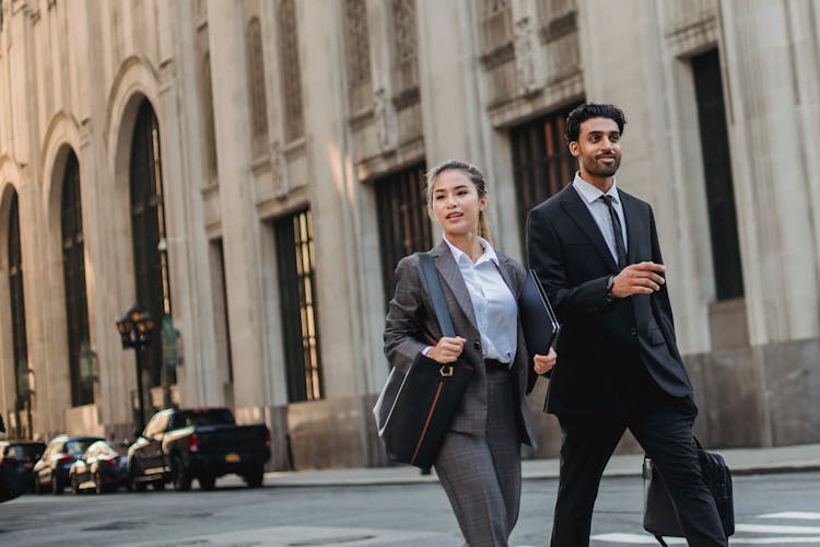 Businessman And Business Woman Walking On A Street