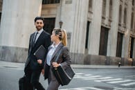 两名穿着西装、提着公文包的商务人士在户外散步