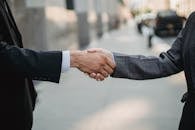 Man in Black Suit Holding Hands With Man in Black Suit