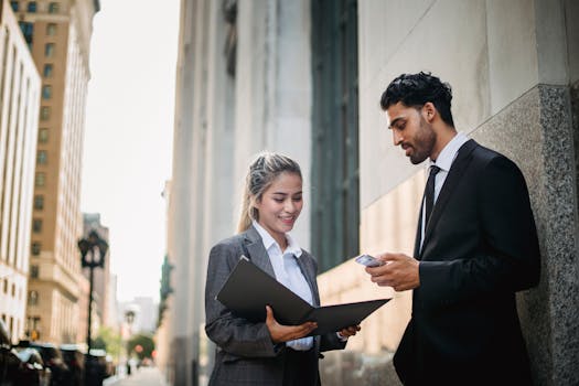 Two business professionals discussing a project outside a city building.
