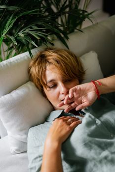 一个短发女人平静地躺在自然光下的沙发上