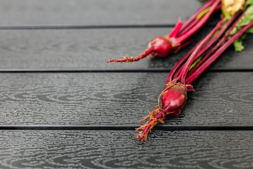 Free Close-Up Shot or Red Beetroot on Brown Wooden Table Stock Photo