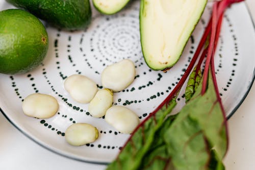 Sliced Green Fruit on White and Black Round Plate