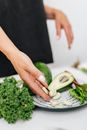 Person Holding Green Vegetable on White Plate