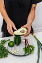 Person Holding Sliced Cucumber and Green Vegetable