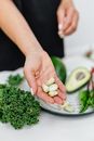 Person Holding Green Vegetable on White Ceramic Plate