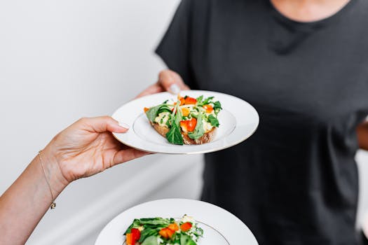 Delicious vegetable toast topped with fresh greens and tomatoes on a white plate.