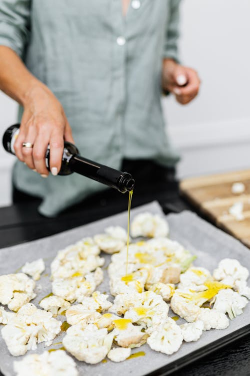 Woman Preparing Cauliflower with Olive Oil