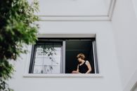 Woman in Black Tank Top Standing Beside Window