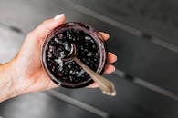 Person Holding Black and Red Round Container