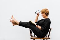 Woman in Black Long Sleeve Shirt Sitting on Brown Wooden Chair