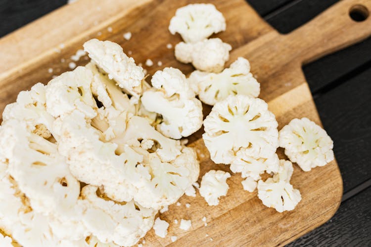 Rosettes Of Cauliflower Lying Chopped On Cutting Desk