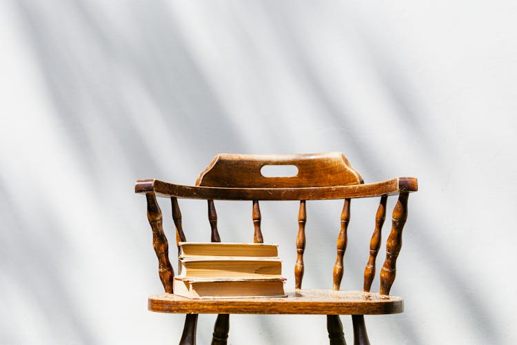 Books Stacked On Top Of Vintage Chair