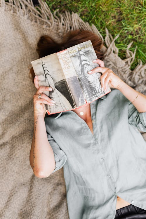 Woman Lying on Blanket Reading Book