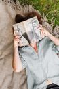 Person in Blue Button Up Shirt Holding a Book