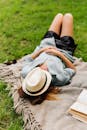 Woman Lying on Grass with Hat on Face 