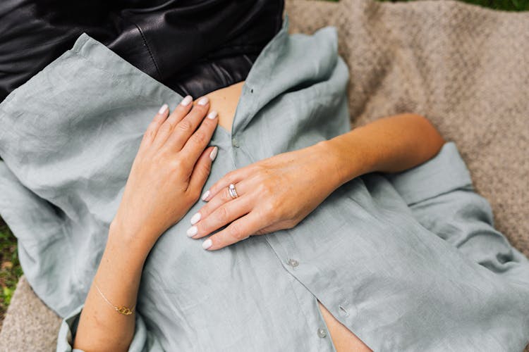 Woman Lying On Back With Hands On Stomach