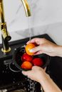 Person Holding Orange Fruit on Stainless Steel Bowl