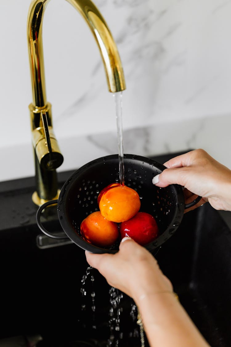 Hands Washing Nectarines In Sink