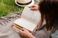 Woman Reading Book Lying Outdoors