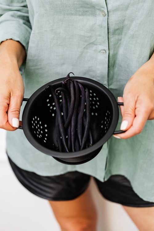 Free Close-up of hands holding a colander filled with fresh black beans. Stock Photo