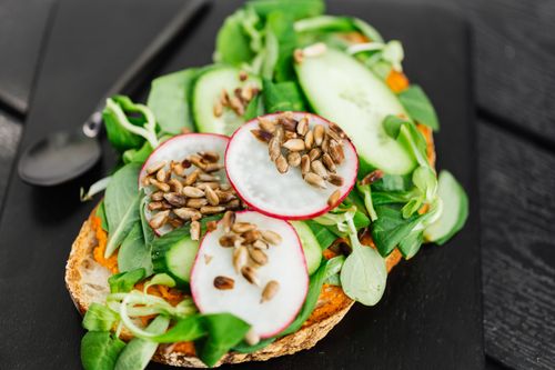 Free A colorful toast topped with fresh vegetables and seeds, perfect for a healthy meal. Stock Photo