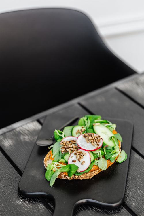 Free Colorful vegan sandwich with sprouts and radishes on a black board, perfect for a healthy lifestyle. Stock Photo