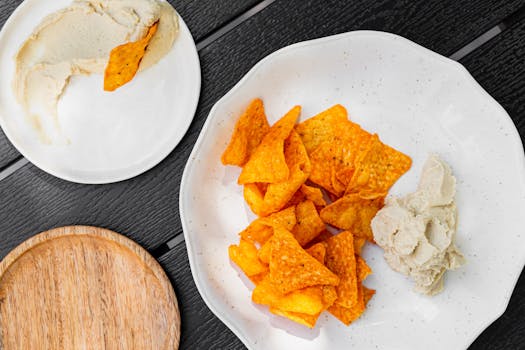 Delicious tortilla chips served with creamy hummus, a perfect snack combo.